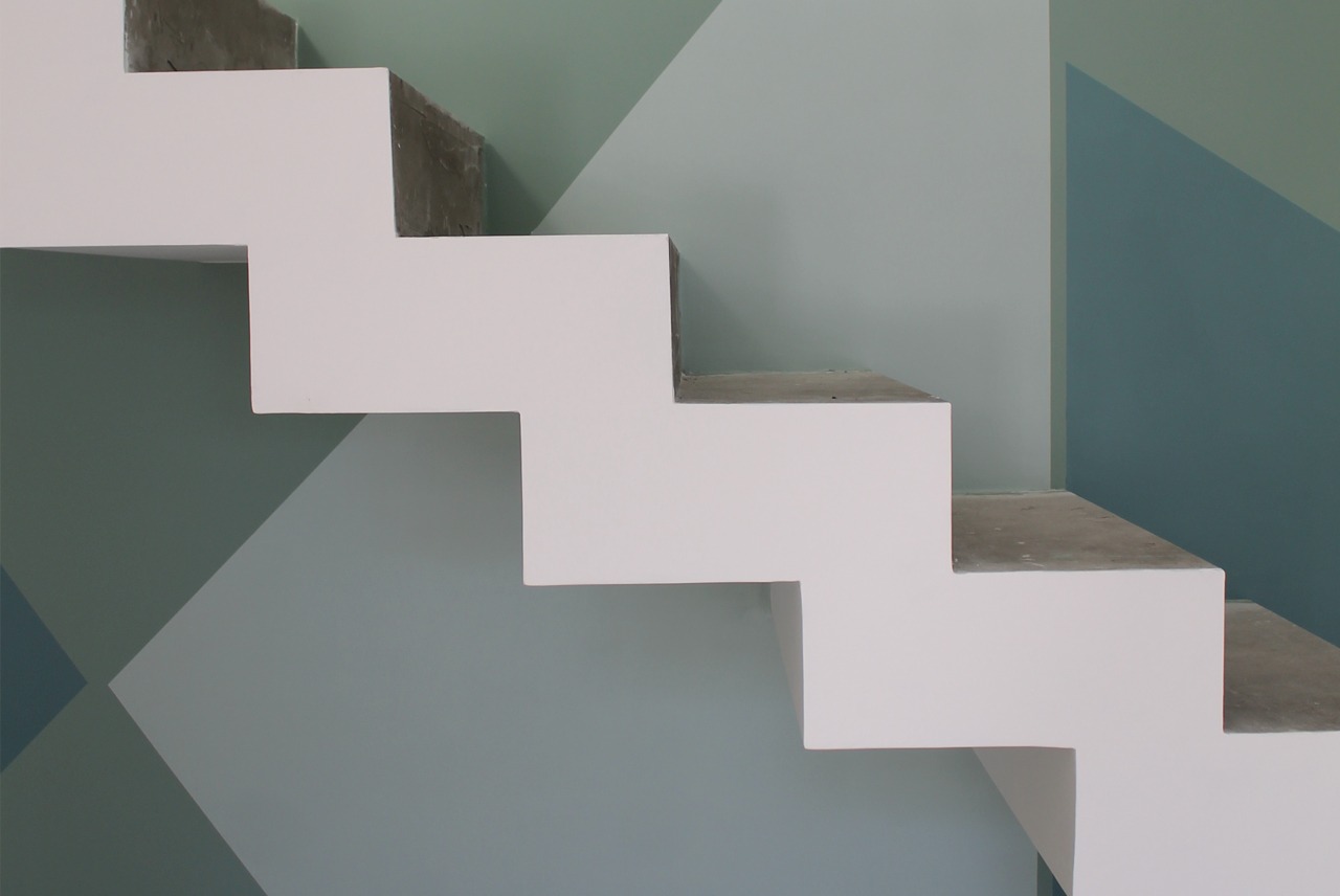foto di decorazione su parete con campire triangolari nei toni del verde e scala moderna bianca usata nella sezione Colore per i tuoi Clienti di Bludiprussia