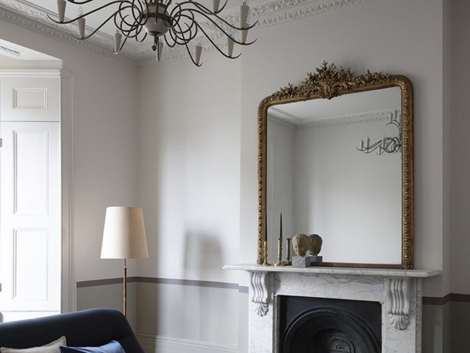soggiorno con pareti bianche camino specchio divano bludiprussia